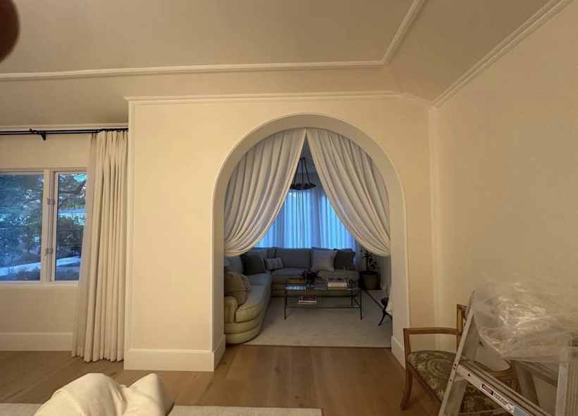 White gathered drapery framing an arched sitting room